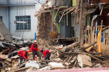 Quito, Ekvator - 09 Aralık 2016: Firemans hasar alan ve yıkım, yangından Inferno binalarda sonra enkaz Temizleme, kimliği belirsiz bir gurup