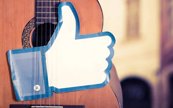 Quito, Ecuador - March 11, 2016: Close up of a guitar with a big like hand printed, in a blurred city background — Stock Photo, Image