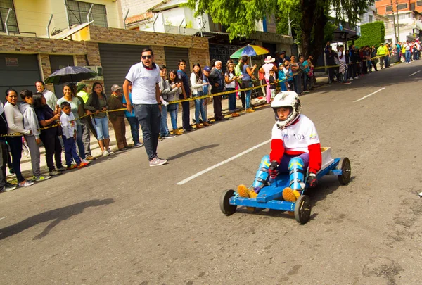 Quito, Equador - 06 de maio de 2017: Um menino não identificado correndo de um carro de madeira em uma estrada urbana dentro das ruas da cidade de Quito — Fotografia de Stock