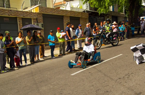 Quito, Ecuador - 2017. május 06.: Egy ismeretlen fiú, egy fából készült versenyautó egy városi közúti belül Quito város utcáin — Stock Fotó