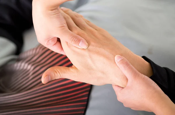 Primer plano de un fisioterapeuta de masaje haciendo masaje de manos de un atleta masculino, en el fondo de consultorio médico —  Fotos de Stock