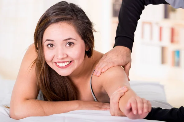 Masaje deportivo. Masajista masajista hombros de una atleta sonriente, trabajando con el músculo Trapezius — Foto de Stock