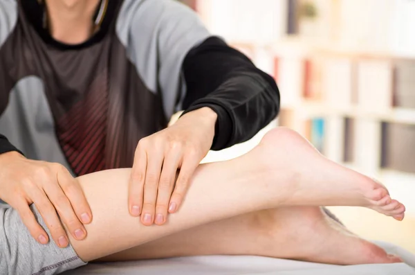 Massage och rehabilitering. Massageterapeut Massera en patienter kalv, i en läkare kontor bakgrund — Stockfoto