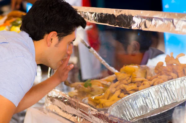 Guapo joven sorprendido observando una deliciosa comida típica andina tradicional ecuatoriana — Foto de Stock