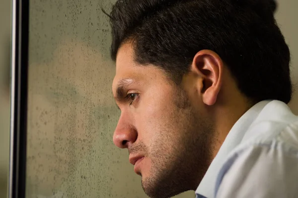 Sad mirrored young man is depresed, gray background