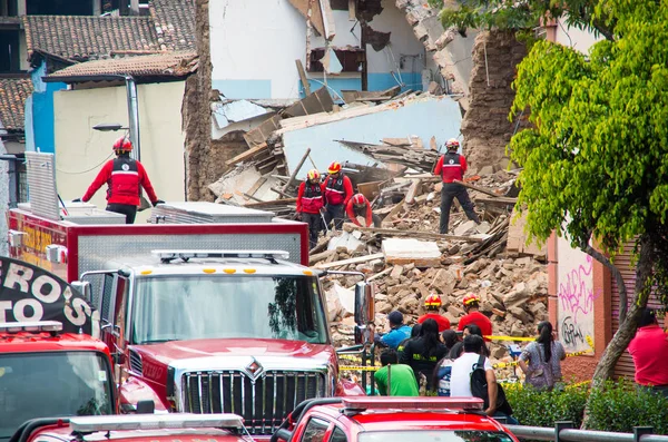 Quito, Ekvator - 09 Aralık 2016: Grup kimliği belirsiz bir kişi ile hasarlı bölgede otopark bir itfaiye araçları