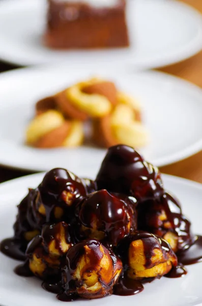 Delicious homemade Profiteroles with chocolate cream on a white plate — Stock Photo, Image