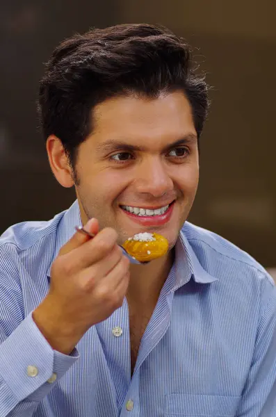 Pohledný muž, jíst chutné turecký dezert sekerpare s kokosovou hnědé pozadí — Stock fotografie