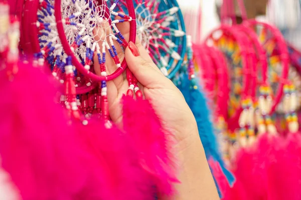 Otavalo, Ecuador - 17 mei 2017: Close up van een vrouw met een roze catchdreamer in haar hand, in kleurrijke markt achtergrond — Stockfoto