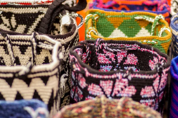 OTAVALO, ECUADOR - MUNGKIN 17, 2017: Cantik andean tradisional tas pakaian benang tekstil dan ditenun dengan tangan di wol, berwarna-warni kain latar belakang — Stok Foto