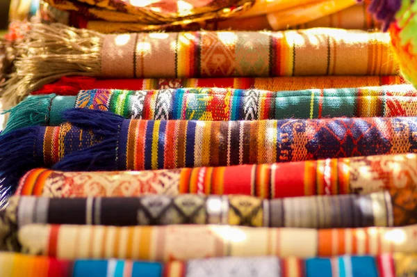 Otavalo, Ecuador - 17 maj 2017: Typisk andinsk tygerna säljs på hantverk marknaden av Otavalo, Ecuador — Stockfoto