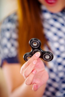 Genç bir kadının elinde tutmak bir popüler topluca spinner oyuncak yakın çekim