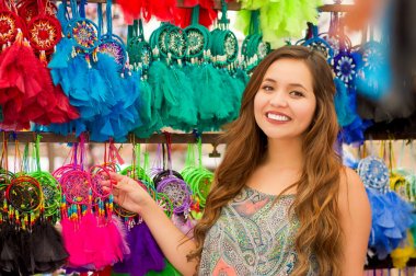 Güzel bir gülümseyen genç kadının renkli Pazar kumaşlar arka planda bir renkli catchdreamers dokunmadan yakın çekim