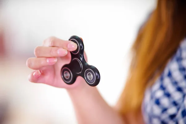 Junge Frau hält ein beliebtes Fidget Spinner Spielzeug in der Hand — Stockfoto