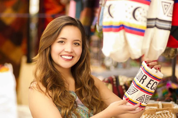Gros plan d'une belle femme tenant un sac à main andin traditionnel vêtements fil textile et tissé à la main en laine, fond de tissus colorés — Photo