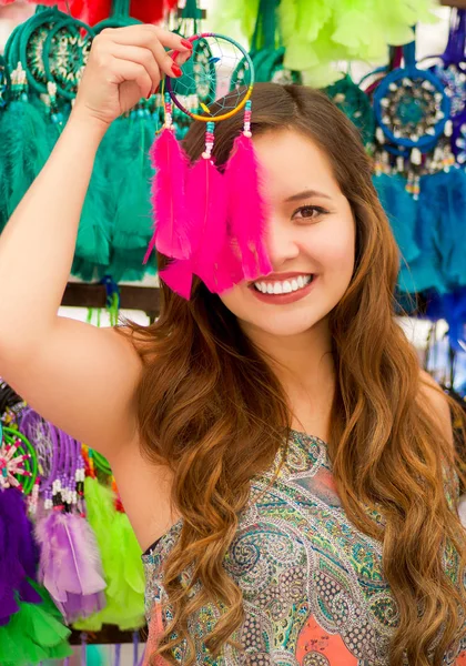 美丽微笑的年轻女子，指向从她脸上的粉红色的 catchdreamers，在彩色市场织物背景 — 图库照片