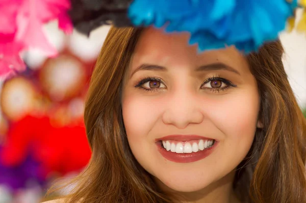 Gros plan d'une femme souriante se cachant derrière un attrapeur de magenta, dans un contexte de marché coloré — Photo