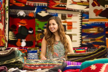 Güzel gülümseyen genç kadın renkli and geleneksel giyim kumaş arka plan ile kamera için poz