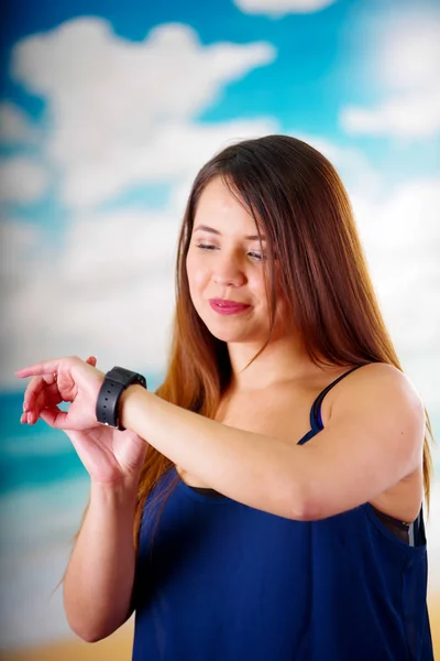 Mujer de negocios que lleva en la muñeca un reloj inteligente con control de voz en un fondo de día soleado — Foto de Stock