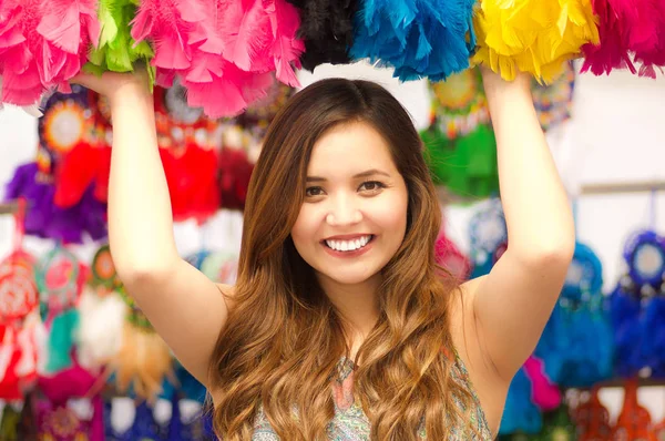 Close-up de uma bela jovem sorridente tocando um coletores coloridos, em fundo tecidos coloridos do mercado — Fotografia de Stock