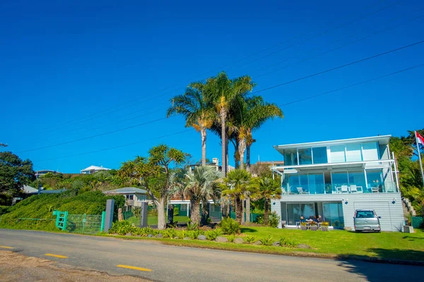 AUCKLAND, NEW ZEALAND- May 12, 2017: Unidentified people sitting in the hall of his house with a beautiful view to the beach in a Waiheke Island, New Zealand with a beautiful blue sky in a sunny day — стоковое фото