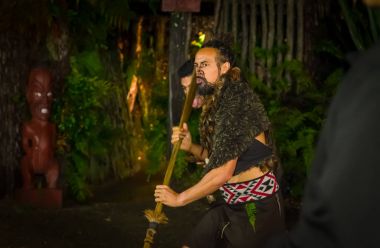 North Island, Yeni Zelanda - 17 Mayıs 2017: Maori adamla bir geleneksel dansı, Tamaki kültür Köyü, Rotorua, Yeni Zelanda Maori kültür, geleneksel elbise geleneksel olarak yüzüne dövmesi