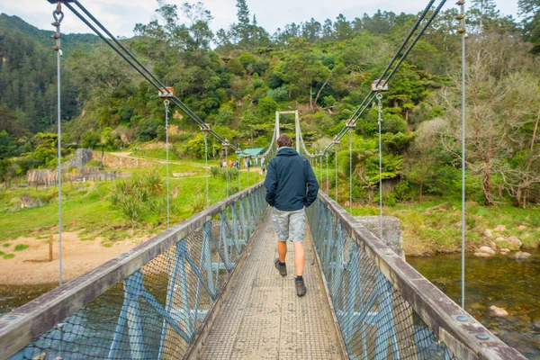 North Island, Új-Zéland - 2017. május 16.: azonosítatlan férfi séta a hídon kell átkelni a folyón meglátogatni karangahake vasúti alagúton keresztül-szurdok, North Island, Új-Zéland — Stock Fotó