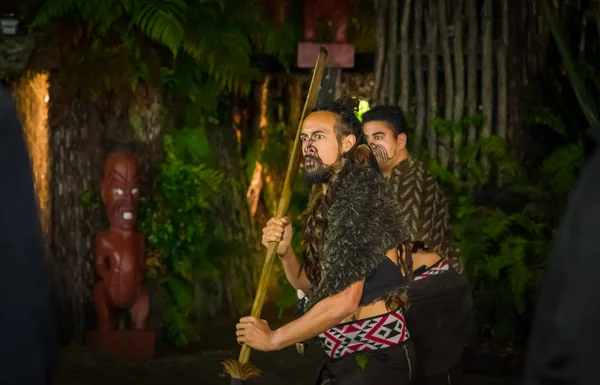 ISLA DEL NORTE, NUEVA ZELANDA - 17 DE MAYO DE 2017: Hombres maoríes con rostro tradicionalmente tatuado en traje tradicional en la cultura maorí haciendo una danza tradicional, Tamaki Cultural Village, Rotorua, Nueva Zelanda — Foto de Stock