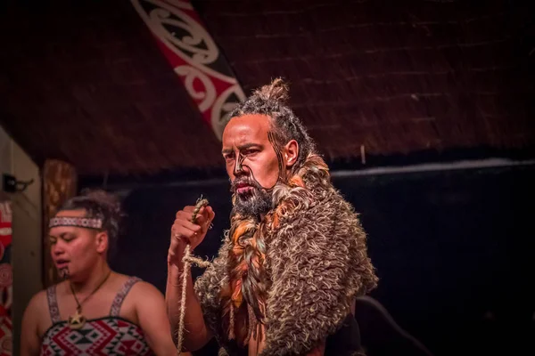 NORTH ISLAND, NEW ZEALAND - MAY 17, 2017: Close up of a Maori man with traditionally tatooed face and in traditional dress at Maori Culture holding in his hands a rope, Tamaki Cultural Village, Rotorua — стоковое фото