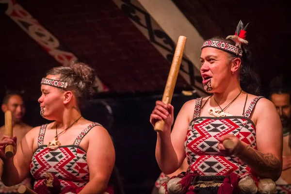 ISOLA DEL NORD, NUOVA ZELANDA - 17 MAGGIO 2017: Primo piano di due donne Tamaki Maori dal volto tradizionalmente tatuato e vestite in modo tradizionale al villaggio culturale Maori con un bastone di legno a Tamaki — Foto Stock