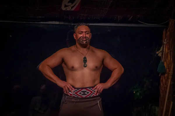 NORTH ISLAND, NEW ZEALAND - MAY 17, 2017: Musculous Tamaki Maori man with traditionally tatooed face and in traditional dress at Maori Culture, Tamaki Cultural Village, in New Zealand — стоковое фото