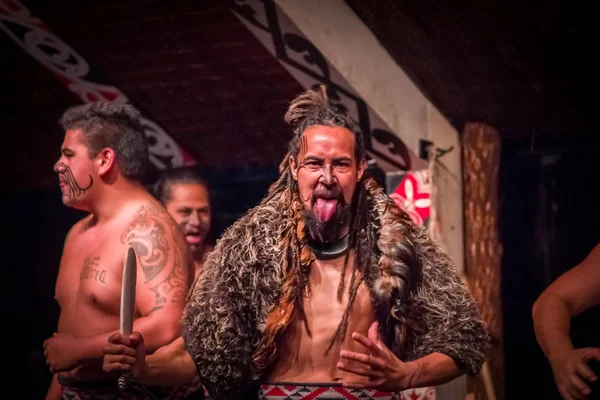 ISLA DEL NORTE, NUEVA ZELANDA - 17 DE MAYO DE 2017: Tamaki Maori hombres uno está sobresaliendo de la lengua con la cara tradicionalmente tatuada y en traje tradicional en la cultura maorí, Tamaki Cultural Village, Rotorua, Nueva — Foto de Stock