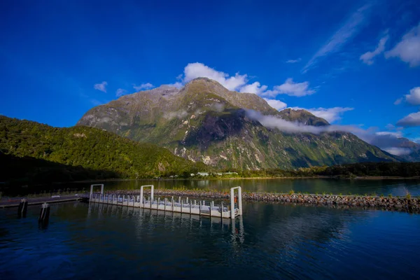 Paisaje de glaciar de alta montaña en milford sonido con un pequeño muelle en el lago, en la isla sur de Nueva Zelanda —  Fotos de Stock