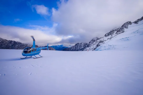 Jižní ostrov, Nový Zéland - 24. května 2017: vrtulník a pilot čekání po sněhu na lovce v Jižní čtvrti Westlands jižních Alp, Nový Zéland — Stock fotografie