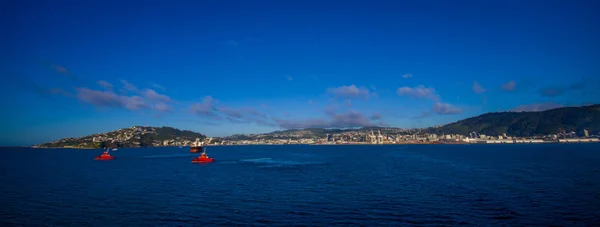Belle vue sur la ville à l'horizontale depuis le ferry entre l'île nord et sud en Nouvelle-Zélande, avec deux yatchs de voile — Photo