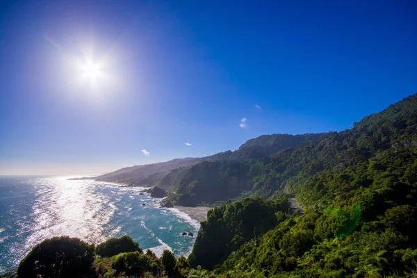 Solen skina över en ö nära Cape Foulwind, vy från Cape Foulwind gångvägen på Seal kolonin, Tauranga Bay. Nya Zeeland — Stockfoto