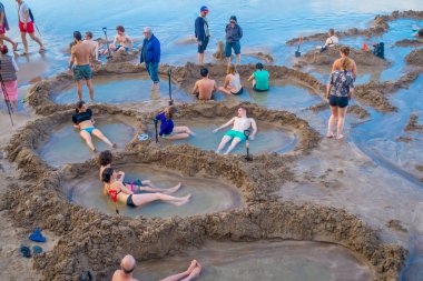North Island, Yeni Zelanda - 16 Mayıs 2017: plaj yaklaşık 700.000 kişi küçük sıcak su havuzları sıcak su beach.it bir Yeni Zelanda jeotermal en popüler turistik yapma ziyaretçiler, ziyaret