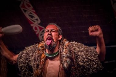 North Island, Yeni Zelanda - 17 Mayıs 2017: dil geleneksel kıyafet, Maori kültür, Tamaki kültür Köyü, Rotorua, Yeni Zelanda ve geleneksel olarak dövmesi yüz ile dışarı yapışmasını Tamaki Maori adam