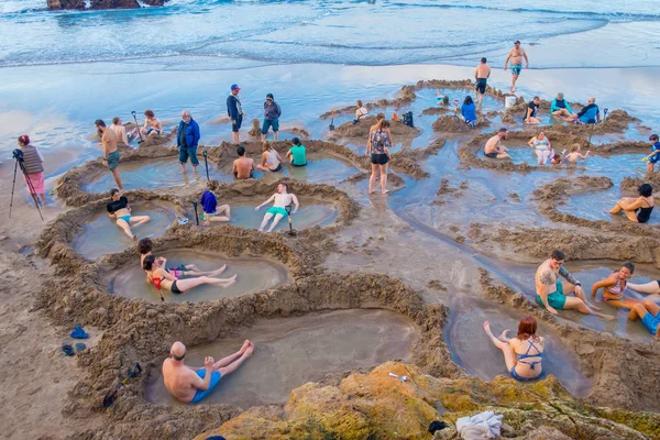 Північний острів, Нова Зеландія - 16 травня 2017: відвідувачів робить невеликий гарячої води басейнів в гарячу воду beach.it, один з найпопулярніших пам'яток геотермальних в Новій Зеландії, близько 700000 людей відвідати пляжі — стокове фото