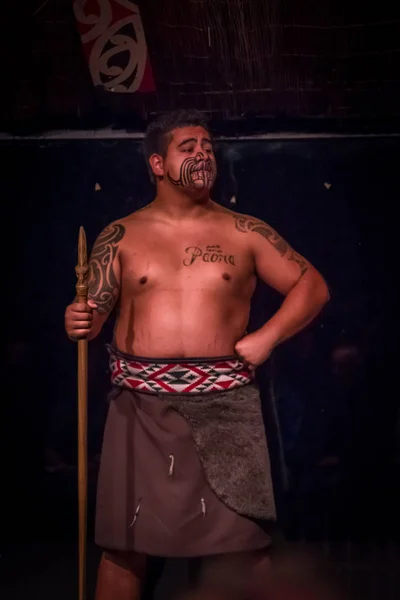 NORTH ISLAND, NEW ZEALAND - MAY 17, 2017: Close up of a Tamaki Maori leader man with traditionally tatooed face and in traditional dress at Maori Culture holding a wood lance, Tamaki Cultural Village — стоковое фото