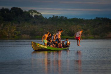 Cuyabeno, Ekvator - 16 Kasım 2016: Genç turist Lagoon Grande günbatımı, Cuyabeno Wildlife Reserve, Güney Amerika karşı içine atlama