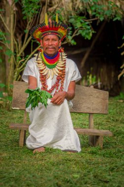 Lago Agrio, Ekvator - 17 Kasım 2016: Geleneksel kıyafet Siona şaman Cuyabeno Wildlife Reserve yerli bir köyde bir tüy şapka ile