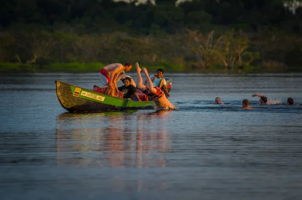 Cuyabeno, Ecuador - 16 November 2016: Jonge toeristen springen in de lagune Grande tegen de zonsondergang, Cuyabeno Wildlife Reserve, Zuid-Amerika — Stockfoto