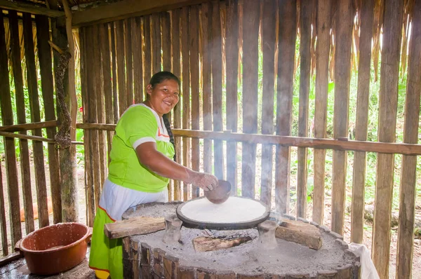 Lago Agrio, Ecuador - 17 November 2016: Kvinna visar matlagning yucca tortillas i en inomhus kök i en Siona by i Cuyabeno Wildlife Reserve, Ecuador — Stockfoto