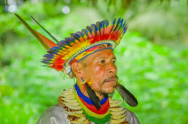 Lago Agrio, Ecuador - 17 November 2016: Porträtt av en Siona shaman i traditionell dräkt med en fjäder hatt i en inhemsk by i Cuyabeno Wildlife Reserve — Stockfoto