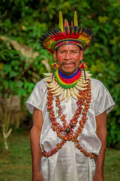 Lago agrio, ecuador - 17. November 2016: siona schamane in traditioneller kleidung mit federhut in einem indigenen dorf im cuyabeno wildlife reservat — Stockfoto