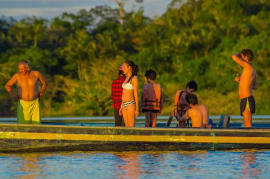 Cuyabeno, Ekvator - 16 Kasım 2016: Genç turist Lagoon Grande günbatımı, Cuyabeno Wildlife Reserve, Güney Amerika karşı içine atlama