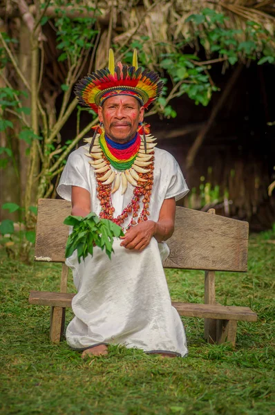 Lago Agrio, Ecuador - 17 November 2016: Siona shaman i traditionell klädsel med en fjäder hatt i en inhemsk by i Cuyabeno Wildlife Reserve — Stockfoto