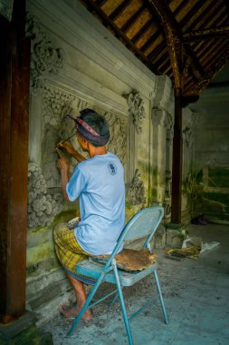 Bali, Endonezya - 08 Şubat 2017: bir duvar çimento, Denpasar Bali sanat yapmak için bir keski kullanarak adam Endonezya'da bulunan