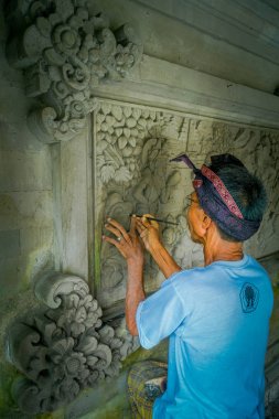 Bali, Endonezya - 08 Şubat 2017: bir duvar çimento, Denpasar Bali sanat yapmak için bir keski kullanarak adam Endonezya'da bulunan